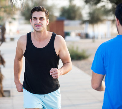 Smiling sportsmen are joggning race in time warm-up
