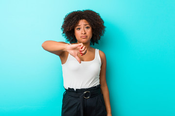 Young african american woman showing a dislike gesture, thumbs down. Disagreement concept.