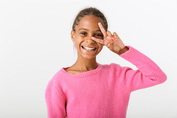 Image of joyful african american girl smiling and gesturing peace sign