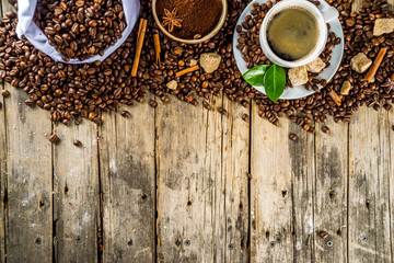 Cup of espresso with coffee beans. ground coffee and leaves on rustic background