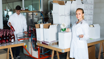 female packing bottles on winery .