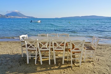 Table set on the beach at a traditional Greek taverna in Gialova on the Navarino Bay in Messinia in the Peloponnese region of Greece near Pylos
