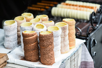 Fototapeta na wymiar Trdelnik or trdlo is traditional czech sweet hollow roll pastry dough sell on market place.
