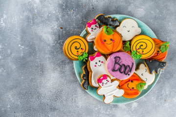 Halloween background with Funny Gingerbread Cookies - pumpkins mummy, zombies, ghosts, spiderweb. Top view with copy space.
