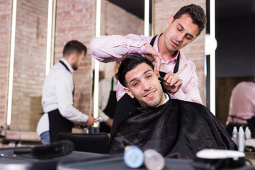 Male getting shave with straight razor in salon