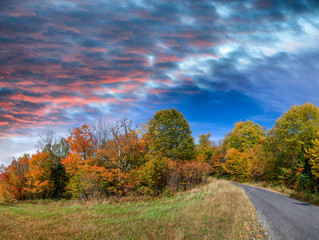 Panoramic view of foliage in New England. Road and trees on a beautiful autumn day