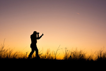Fototapeta na wymiar Young girl silhouette looking through binoculars