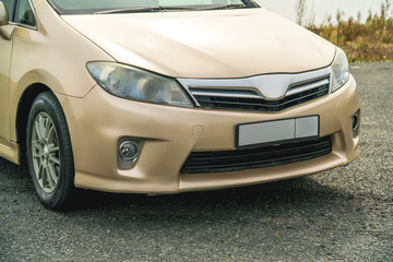 Photo of a car of golden color standing on the street