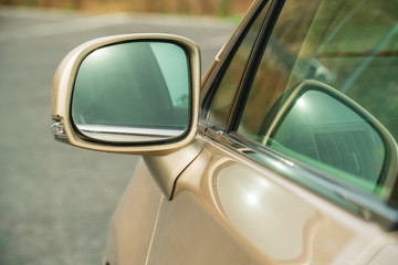 Photo of rear-view side mirror on a gold-coloured car