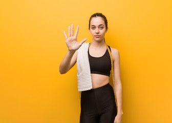 Young fitness girl showing number five