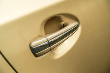 Photo of door chrome handle of car of gold color