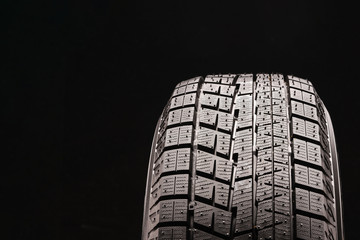 new non-directional asymmetric friction winter tire Velcro without spikes on black background....