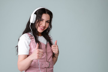 Awesome brunette lady in pink leather dress listen for her favourite music with white headphones....
