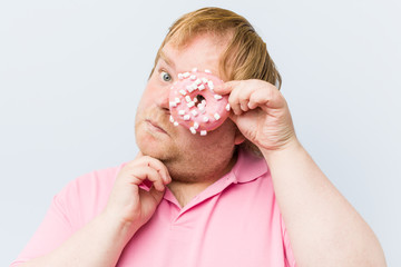 Caucasian crazy blond fat man holding a donuts