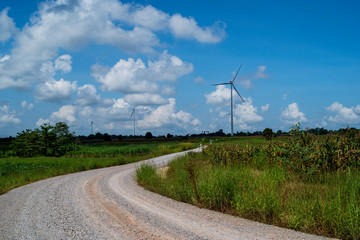 Fototapeta na wymiar rural road to wind turbine