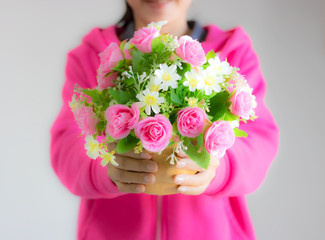 Girl wearing pink blurred image holding a bouquet of colorful flowers deliver to lover. Giving good feelings to each other pink flowers represent love and care. White represents purity.