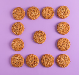 Round oatmeal cookies on a purple background.