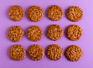 Round oatmeal cookies on a purple background.