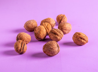 Walnuts on a dark purple surface.