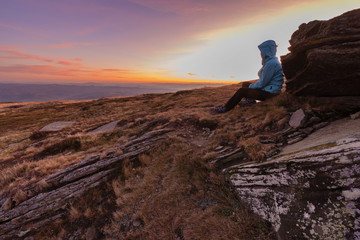 Fototapeta premium Young girl travels through beautiful mountain ranges with fantastic views of autumn meadows and peaks