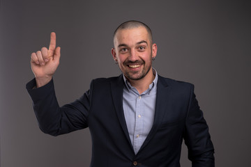 Portrait of delighted manager raising his forefinger up