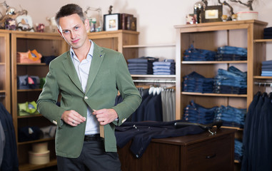 Positive male customer choosing fashion suit