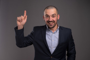 Enthusiastic man pointing upwards with her index finger