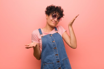Young mixed african american teenager woman doubting between two options.