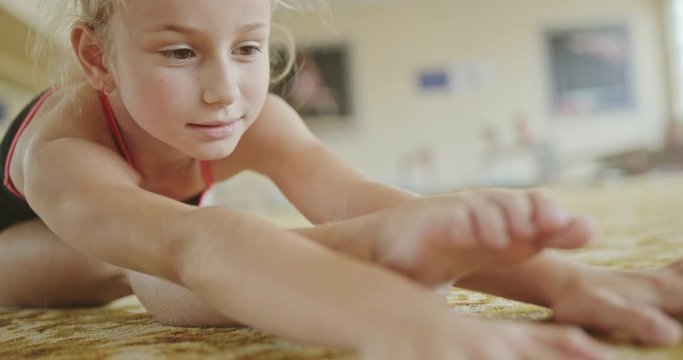 Little girl stretching in front splits