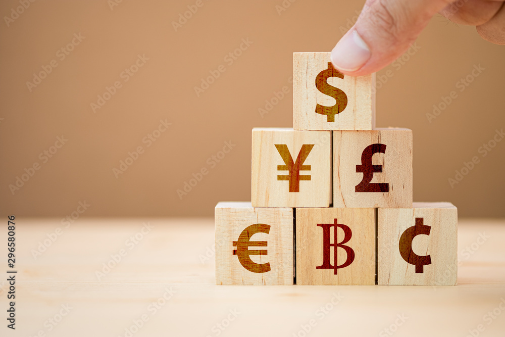 Wall mural hand putting wooden cube of us dollar sign to yuan yen euro and pound sterling sign.us dollar is mai