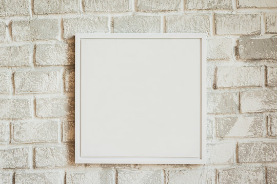 Realistic empty  white frame on light background, border for your creative project. Blank paper frames on white wall with shadow from light.