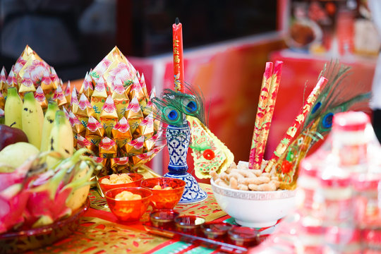 Chinese New Year Decoration. Festive food,  fresh fruits and other set up for Chinese New Year festival with soft focus on the joss paper in golden offering dish. Chinese words meaning life and water