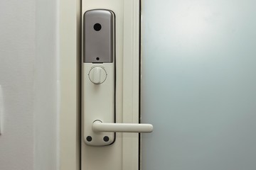 Close up view of an electric combination lock on a white door. Interior design. Beautiful backgrounds.