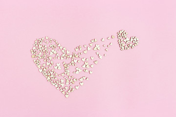 Small heart emerges from large one. Birth of new love. Concept of love. Many small wooden hearts on...