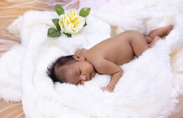 Obraz na płótnie Canvas The newborn baby sleeping on cotton soft cloth,with happy emotion,blurry light around