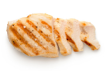 Partially sliced grilled chicken breast with grill marks, ground black pepper and salt isolated on...