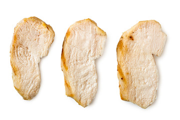 Three separated slices of grilled chicken breast isolated on white. Top view.