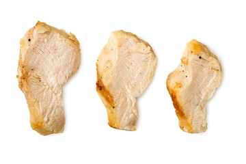 Three separated slices of grilled chicken breast isolated on white. Top view.