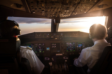 Piloten im Cockpit bei Sonnenaufgang 