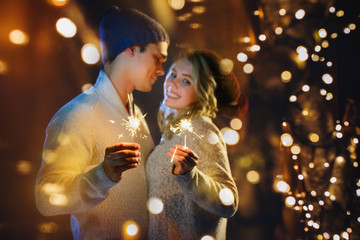 Obraz na płótnie Canvas A couple celebrates Christmas together with lights
