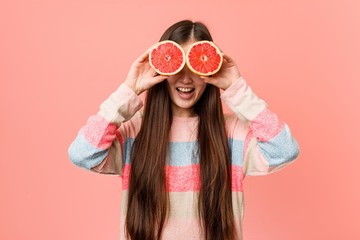 Young asian woman playing with a grapefruit