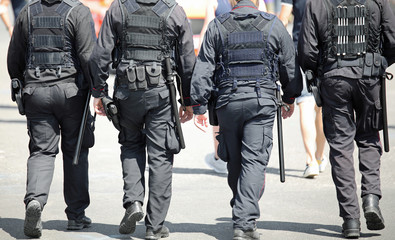 four policemen of special force unit patroling the city