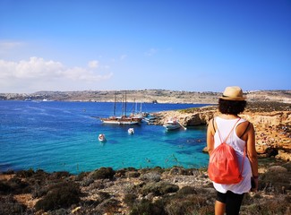 tourist from behind blue lagoon in comino, Malta