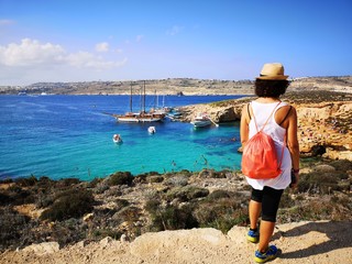 tourist from behind blue lagoon in comino, Malta