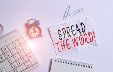 Writing note showing Spread The Word. Business concept for share the information or news using social media Blank paper with copy space on the table with clock and pc keyboard
