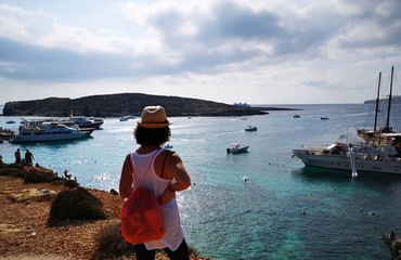 tourist from behind blue lagoon in comino, Malta