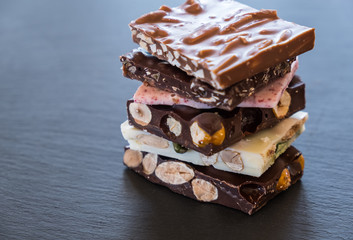 Stack of milk and dark chocolate with nuts and berries