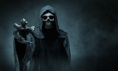 Grim reaper reaching towards the camera over dark background with copy space - obrazy, fototapety, plakaty