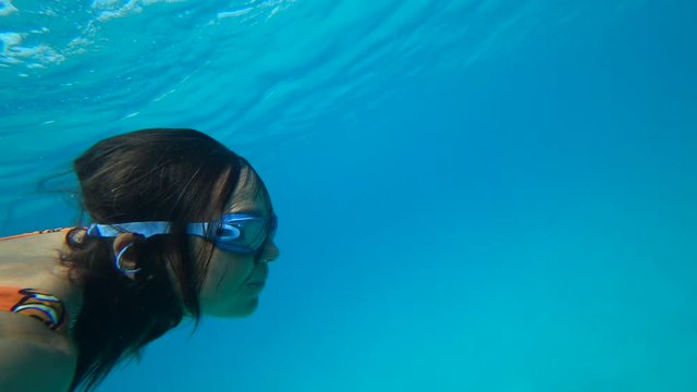 Kekova, Turkey - 30th of September 2019: 4K Side selfie Woman makes a roll over back underwater