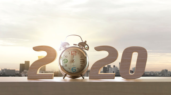 2020 happy new year. Resolutions, goals, start up, refresh concept. Wood numbers and clock on wooden tabletop on panoramic skyline and buildings in the morning background.